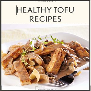 Healthy tofu and mushroom dish served with pasta and creamy sauce on a white plate