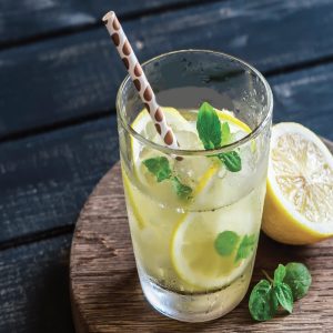 Glass of refreshing lemon cooler with mint leaves and ice, served with a slice of lemon β a perfect drink for Ramadan.